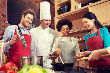 Image showing happy friends and chef cook cooking in kitchen