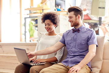 Image showing happy creative team with laptop in office