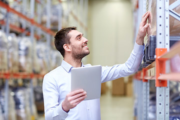 Image showing happy businessman with tablet pc at warehouse