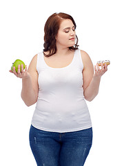 Image showing young plus size woman choosing apple or cookie