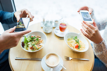 Image showing close up of couple picturing food by smartphone