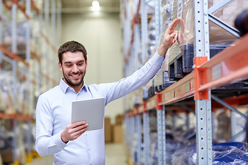 Image showing happy businessman with tablet pc at warehouse