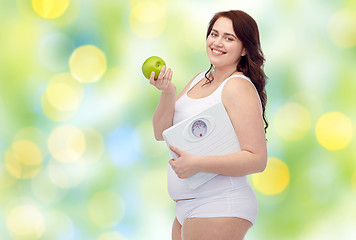 Image showing happy young plus size woman holding scales