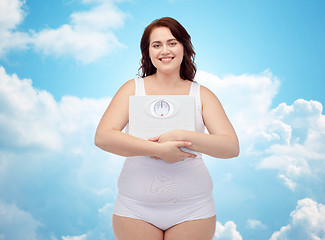 Image showing happy young plus size woman holding scales