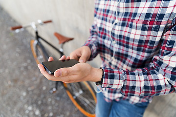 Image showing close up of hipster man with smartphone and bike