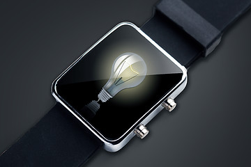 Image showing close up of black smart watch with light bulb