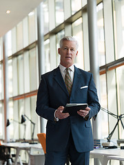 Image showing senior business man working on tablet