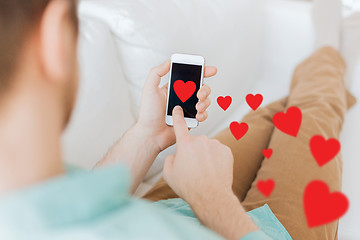 Image showing close up of man sitting with smartphone at home