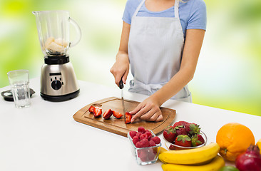 Image showing close up of woman chopping strawberry at home