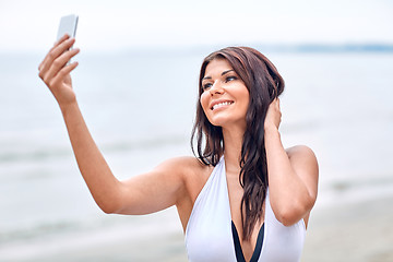 Image showing smiling young woman taking selfie with smartphone