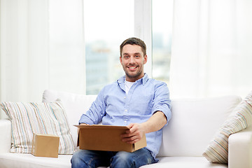 Image showing happy man with cardboard boxes or parcels at home