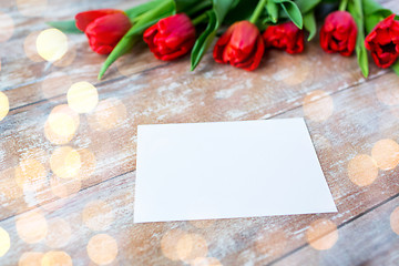 Image showing close up of red tulips and blank paper or letter