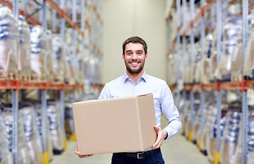 Image showing happy man with cardboard parcel box at warehouse