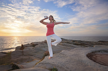 Image showing Woman balance drinking wqter during exercise