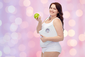 Image showing happy young plus size woman holding scales