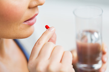 Image showing close up of woman taking medicine in pill