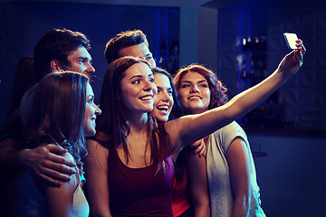 Image showing friends with smartphone taking selfie in club