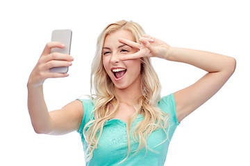 Image showing smiling young woman taking selfie with smartphone