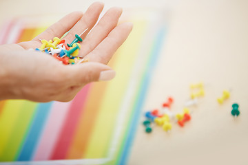 Image showing Hand with colorful pushpins