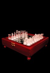 Image showing Chess on a mirror wooden board, on a black background.