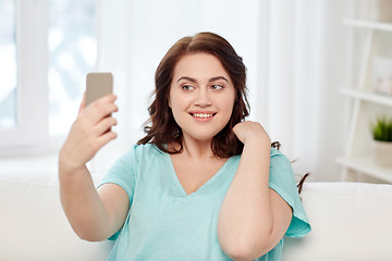 Image showing happy plus size woman with smartphone at home