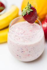 Image showing close up of glass with milk shake and fruits