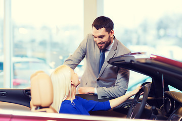 Image showing happy couple buying car in auto show or salon