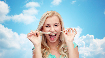 Image showing happy young woman making mustache with her hair