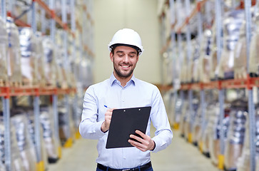 Image showing happy businessman with clipboard at warehouse