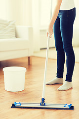 Image showing close up of woman with mop cleaning floor at home