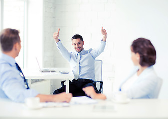 Image showing happy businessman showing thumbs up in office