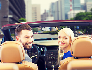 Image showing happy couple driving in cabriolet car over city