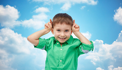 Image showing happy little boy having fun and making horns