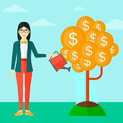 Image showing Woman watering money tree.