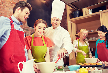 Image showing happy friends and chef cook baking in kitchen