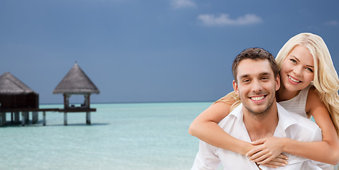 Image showing happy couple having fun over beach with bungalow