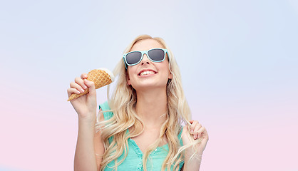 Image showing happy young woman in sunglasses eating ice cream