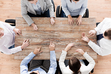Image showing close up of business team sitting at table