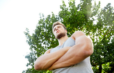 Image showing sporty young man with crossed arms at summer park