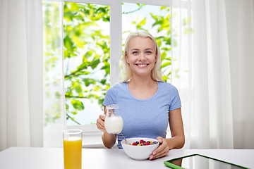 Image showing woman with milk and cornflakes eating breakfast