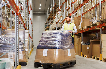 Image showing man carrying loader with goods at warehouse