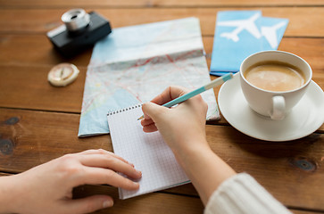 Image showing close up of traveler hands with notepad and pencil