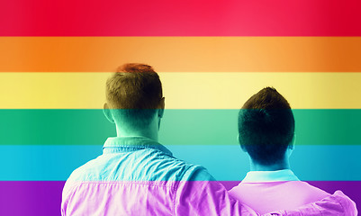 Image showing close up of male gay couple over rainbow flag