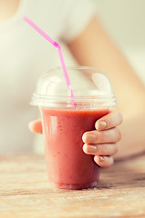 Image showing close up of woman holding cup with smoothie