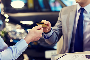 Image showing customer giving credit card to car dealer in salon