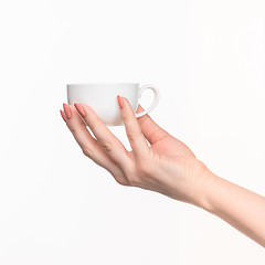 Image showing Woman hand with cup on white background