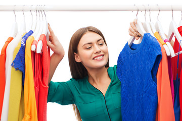 Image showing happy woman choosing clothes at home wardrobe