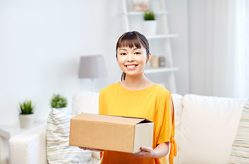 Image showing happy asian young woman with parcel box at home