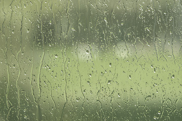 Image showing Window with rain drops in green color