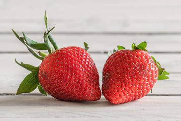 Image showing Two strawberries on a wooden table